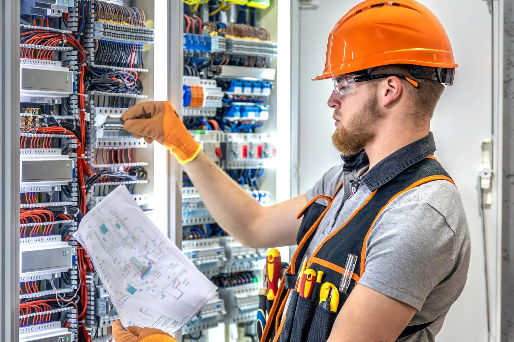 Commercial electrician working on a multi-circuit distribution panel at a Leeds business premises, work backed by a written guarantee
